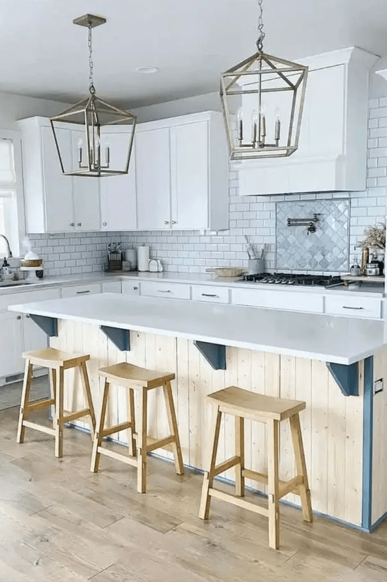 a vintage farmhouse kittchen with white shaker cabinets, a white subway tile bacjsplash, a planked kitchen island and pendant lamps