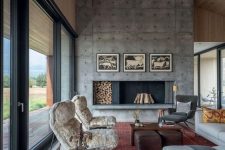 a welcoming modern living room with an oversized concrete fireplace, chic furniture and printed textiles is very cool