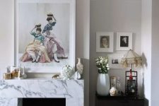 a whimsical vintage-inspired living room with a non-working fireplace clad with white marble and beautiful artworks