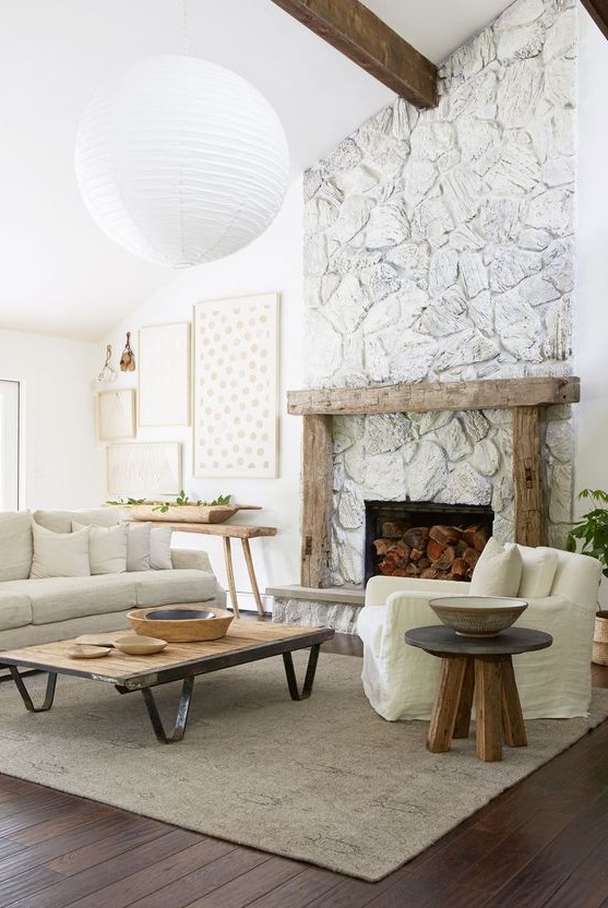 a whimsy neutral living room with plenty of texture, a whitewashed stone fireplace with a rough wooden mantel