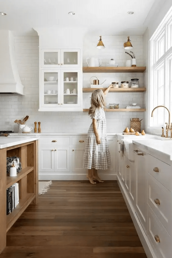 a white farmhouse kitchen with white stone countertops, a white subway tile backsplash, open shelves, a stained kitchen island