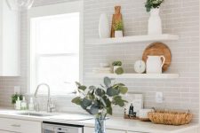 a white kitchen finished off with dove grey subway tiles and touches of greenery looks fresh and ethereal