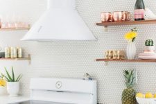 a white penny tile backsplash paired with a white stone countertop and wooden shelves create a chic look