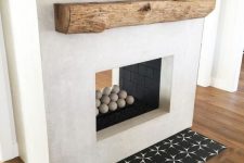 a white two-sided concrete fireplace with mosaic tiles and a rough wooden mantel is very bold and cool
