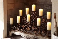 a wrought candle stand with vignettes right in the fireplace is a refined idea to try