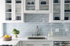 an airy white kitchen with a light blue subway tile backsplash and neutral metallics is very welcoming