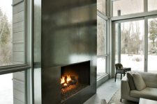 an ultra-modern fireplace clad with dark metal sheets looks very eye-catching and even show-stopping