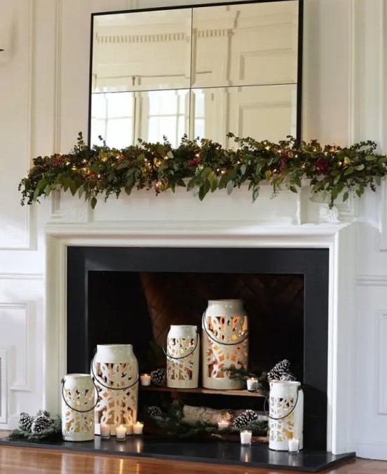 Beautiful white snowflake candle lanterns with candles, pinecones and fir branches for a holiday ready fireplace