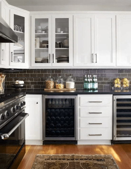 dark chocolate subway tiles with white grout make up a contrasting and bold kitchen backsplash
