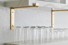 white penny tiles, white marble shelves and gold fixtures for a chic contemporary look