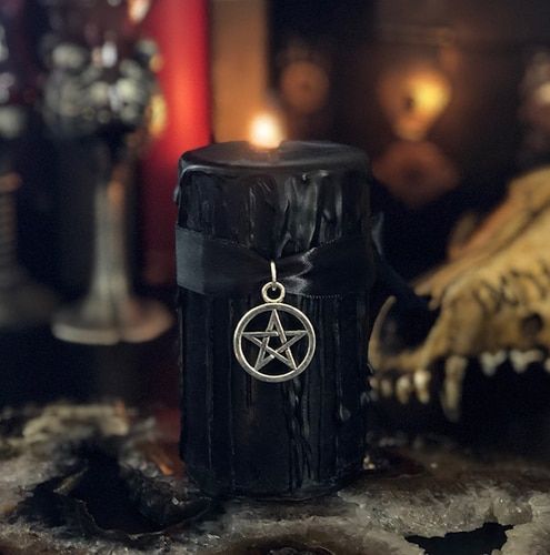 a black candle with black drip, a star pendant on a black ribbon is a stylish witches' inspired idea
