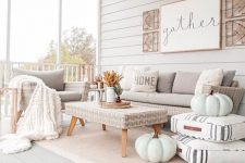 03 an elegant and cozy neutral porch stylish with neutral furniture, textiles, chalk painted pumpkins, some fall leaf arrangements and a sign