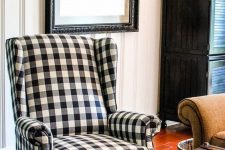 07 a French farmhouse nook with a plaid wingback chair, a chest and an artwork for a stylish rustic look