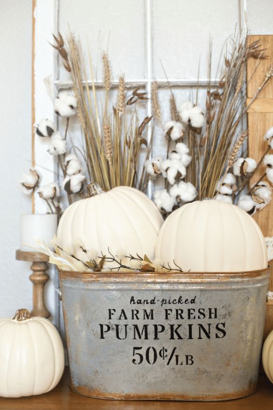 a rustic fall arrangement - cotton, wheat and white pumpkins in a vintage rustic bathtub plus white candles