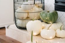 08 classy fall decor of a wire basket with white pumpkins, white and green pumpkins and lights is very cool and easy
