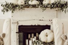 a modern fall mantel decor with lots of greenery
