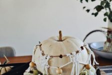 09 boho Halloween styling with a neutral pumpkin with macrame and beads plus some blooms and feathers