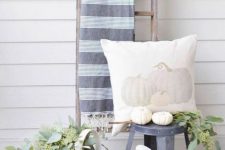 10 neutral fall decorating with natural pumpkins, greenery, a white watering can and a pumpkin pillow
