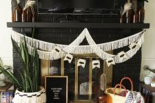 11 a boho Halloween fireplace with a fringe garland, potted succulents, feathers in bottles and pumpkins