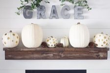 11 a stylish modern fall mantel with white and polka dot pumpkins and pinecones, metal letters and greenery