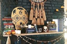 12 a boho Halloween mantel with a fringe and tassel hanging, a cutout skull, some garlands and tassels and mini pumpkins