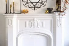 12 a stylish modern fall mantel with branches with berries, mini pumpkins on a gold stand and candles in candleholders