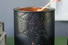 17 a simple Halloween candle lantern made of a tin can with a spiderweb and a candle inside
