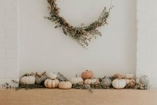 17 a stylish and natural fall mantel with natural pumpkins, greenery, berries and a matching round wreath over the mantel