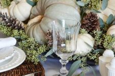 21 a neutral rustic table setting with woven placemats, white plates and napkins, all-natural pumpkins, greenery and pinecones