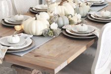 23 a simple and elegant neutral tablescape with a grey runner and printed napkins, white and grey pumpkins, candles and faux blooms