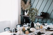 24 a stylish modern fall tablescape with faux and natural pumpkins, greenery, black plates and pots with soup