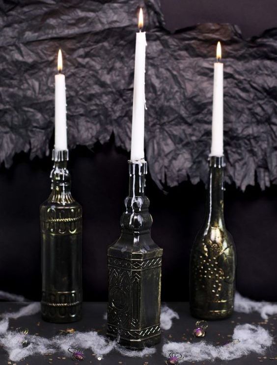 vintage bottles painted black and bronze to make the look like refined metal candleholders are chic and elegant