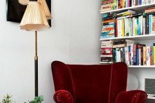 26 a whimsical reading nook with a burgundy velvet wingback chair, a bookshelf, a bold artwork and greenery