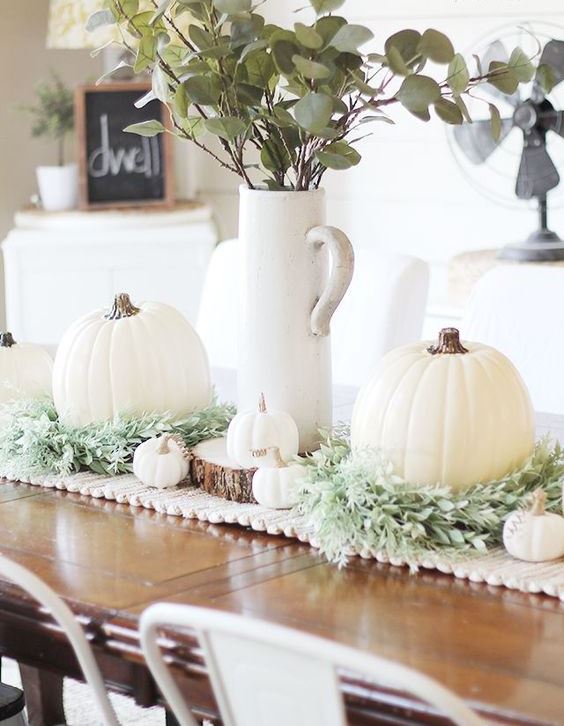 chic fall table styling with a crochet runner, greenery, white pumpkins and a leaf arrangement in a jug