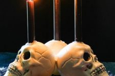 26 white skull candleholders with black candles are perfect for decorating your space for Halloween, simple and traditional