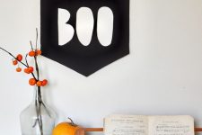 a BOO banner, a pumpkins and dried blooms in a bottle for simple and minimal Halloween styling