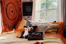 a Halloween-ready bedroom with a bright mandala on the wall, bright Halloween bedding and pillows