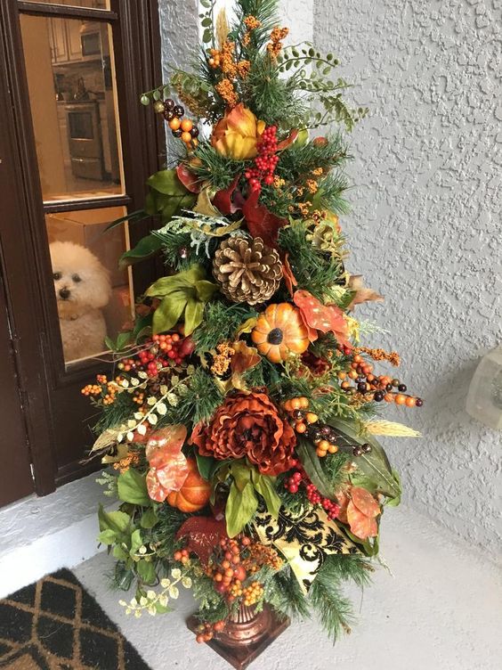 a Thanksgiving tree with faux blooms, pumpkins, fruits, berries, greenery and oversized pinecones is very lush