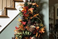 a Thanksgiving tree with leaves, faux and fabric pumpkins, faux leaves, husks, berries and glitter ribbons
