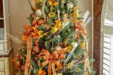 a Thanksgiving tree with lights, plaid ribbon bows, gilded pumpkins, fall leaves, twigs and shiny metallic ornaments