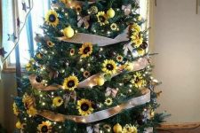 a Thanksgiving tree with ribbons, sunflowers and faux yellow blooms, yellow and black ornaments and lights
