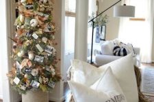 a Thanksgiving tree with white pumpkins, acorns, leaves, lights, pinecones, grasses and family pics is very cute