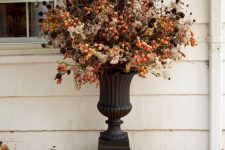 a bold outdoor floral arrangement for Halloween done with berries and dried blooms and foliage