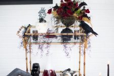 a dark Halloween centerpiece of red, black blooms, dark foliage and bright yellow touches