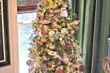 a fall tree with owls, lights, pumpkins, vine balls, branches, ribbons and feathers on the top