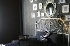 a moody Halloween bedroom in black, with a scary gallery wall, a mirror and some cool spooky pillows