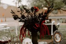 a refined Halloween floral arrangement with black adn red blooms and black painted bunny tails