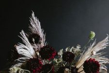 a refined Halloween floral arrangement with dark dahlias, dried blooms, leaves and grasses is a very stylish idea