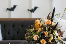 a refined moody Halloween centerpiece with yellow and orange blooms, greenery, grasses and catchy textures