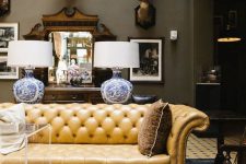 a sophisticated living room with a yellow leather Chesterfield sofa, taxidermy, plexiglass items and refined lamps